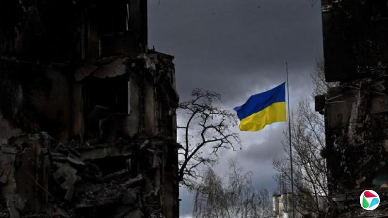 The Ukrainian flag flutters between buildings destroyed in bombardment, in the Ukrainian town of Borodianka, in the Kyiv region on April 17, 2022. - Russia invaded Ukraine on February 24, 2022